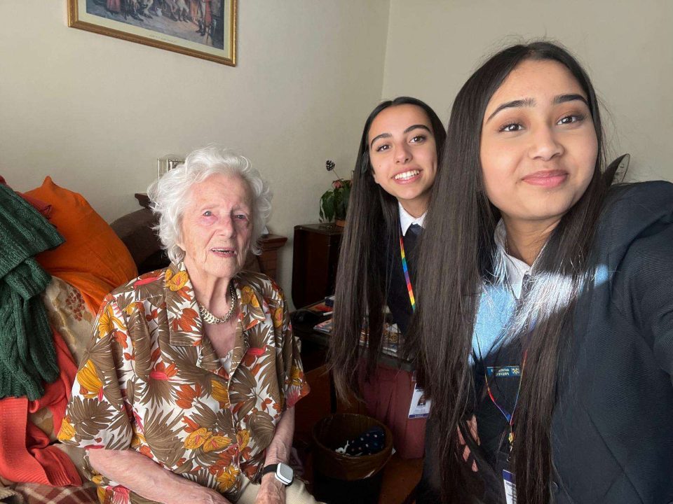 Young volunteers Simar and Nikki with client Pearl